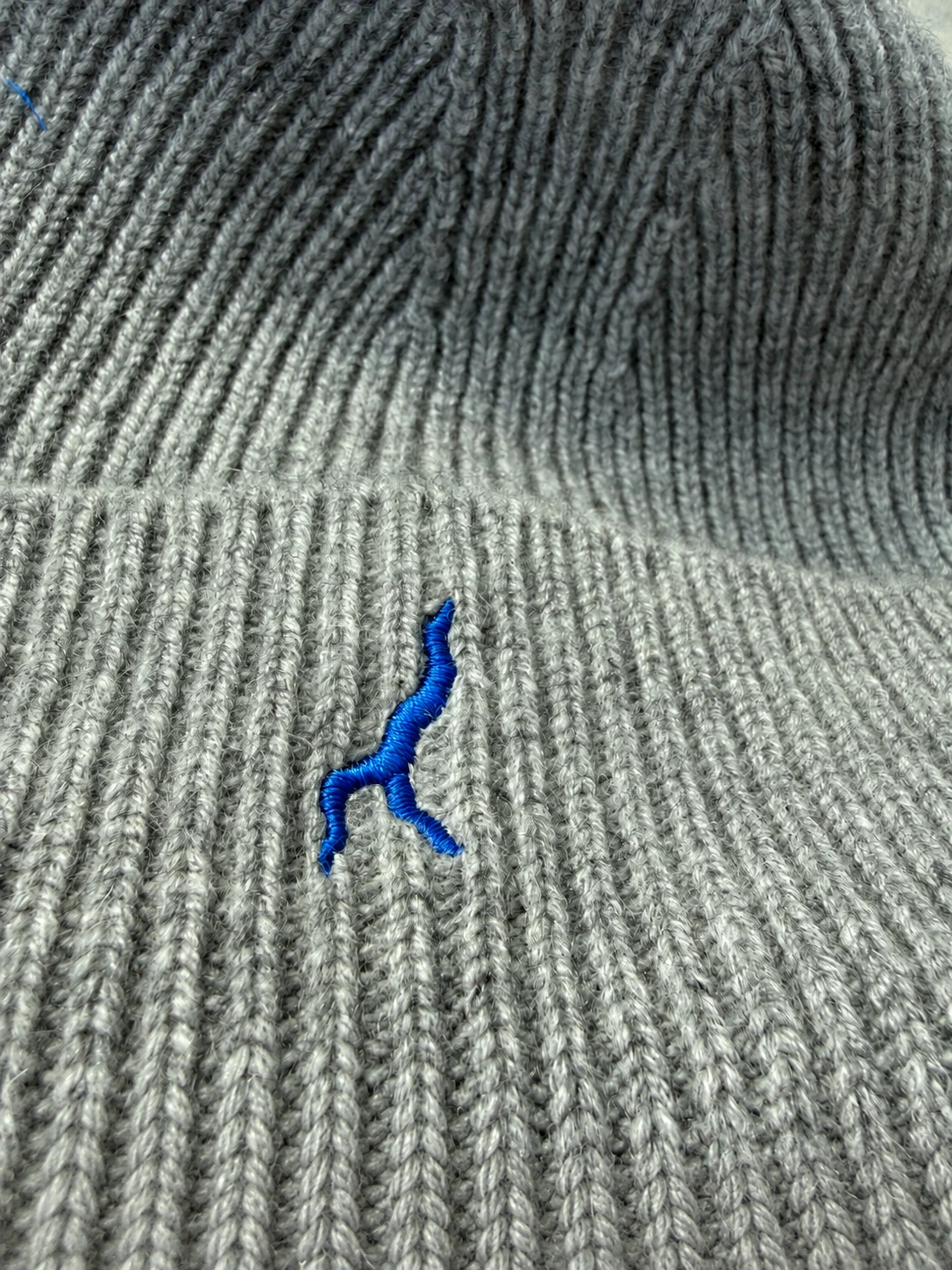 Menaggio — macro del profilo del Lago di Como ricamato in blu sul cashmere grigio